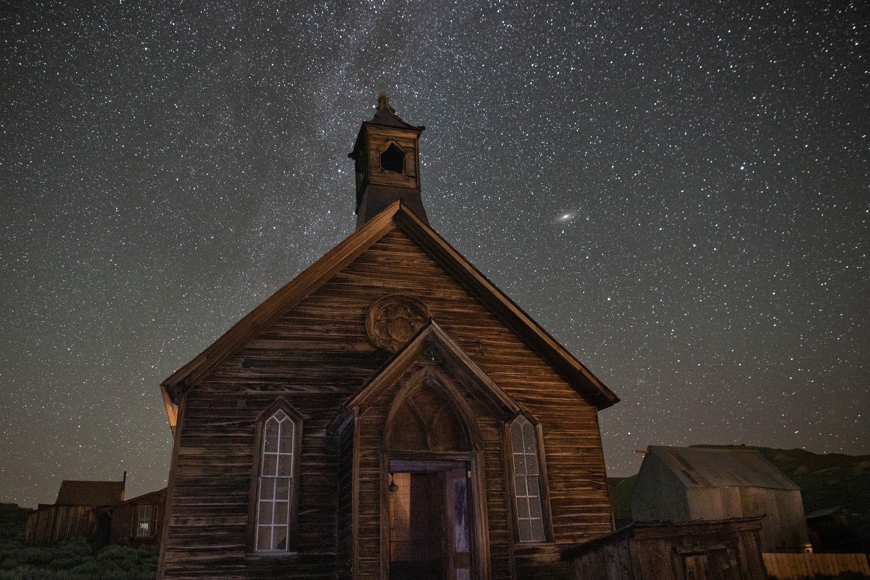 an old wooden church at night under a starry sky