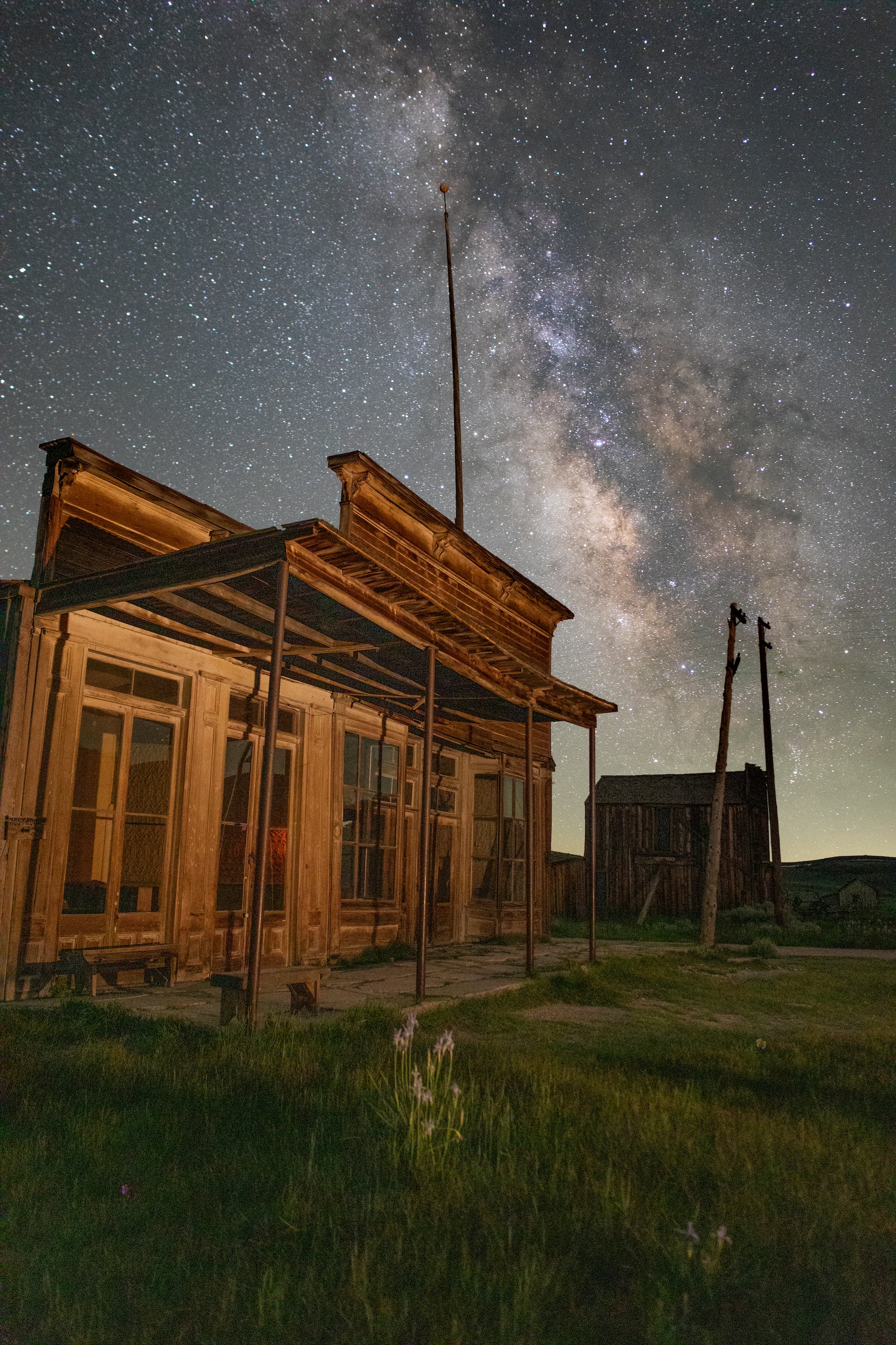 an old wooden building with large windows in front at night under a starry sky